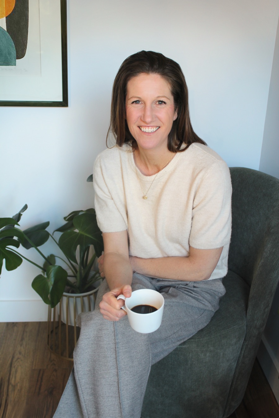 Amy Mills-Guest seated in her counselling office holding a mug